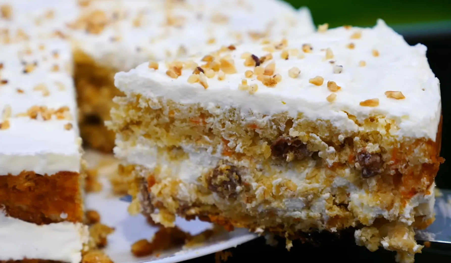 Отрезанный кусочек сметанника с изюмом на тарелке