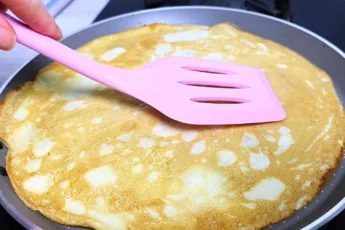 Тонкие ажурные блины на минеральной воде в мелкую дырочку стопкой на тарелке