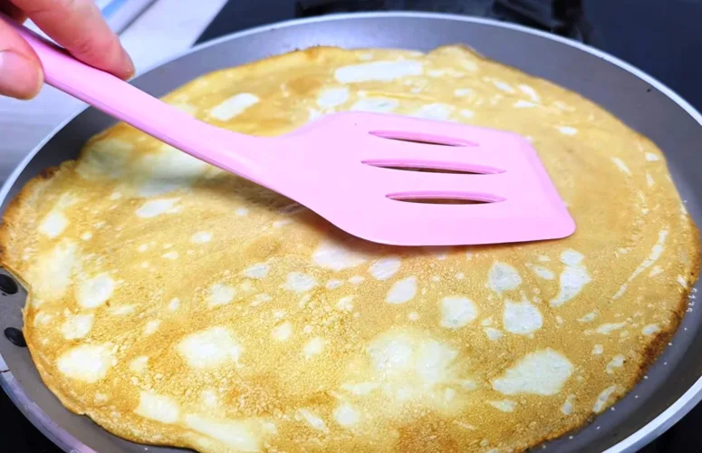 Тонкие ажурные блины на минеральной воде в мелкую дырочку стопкой на тарелке