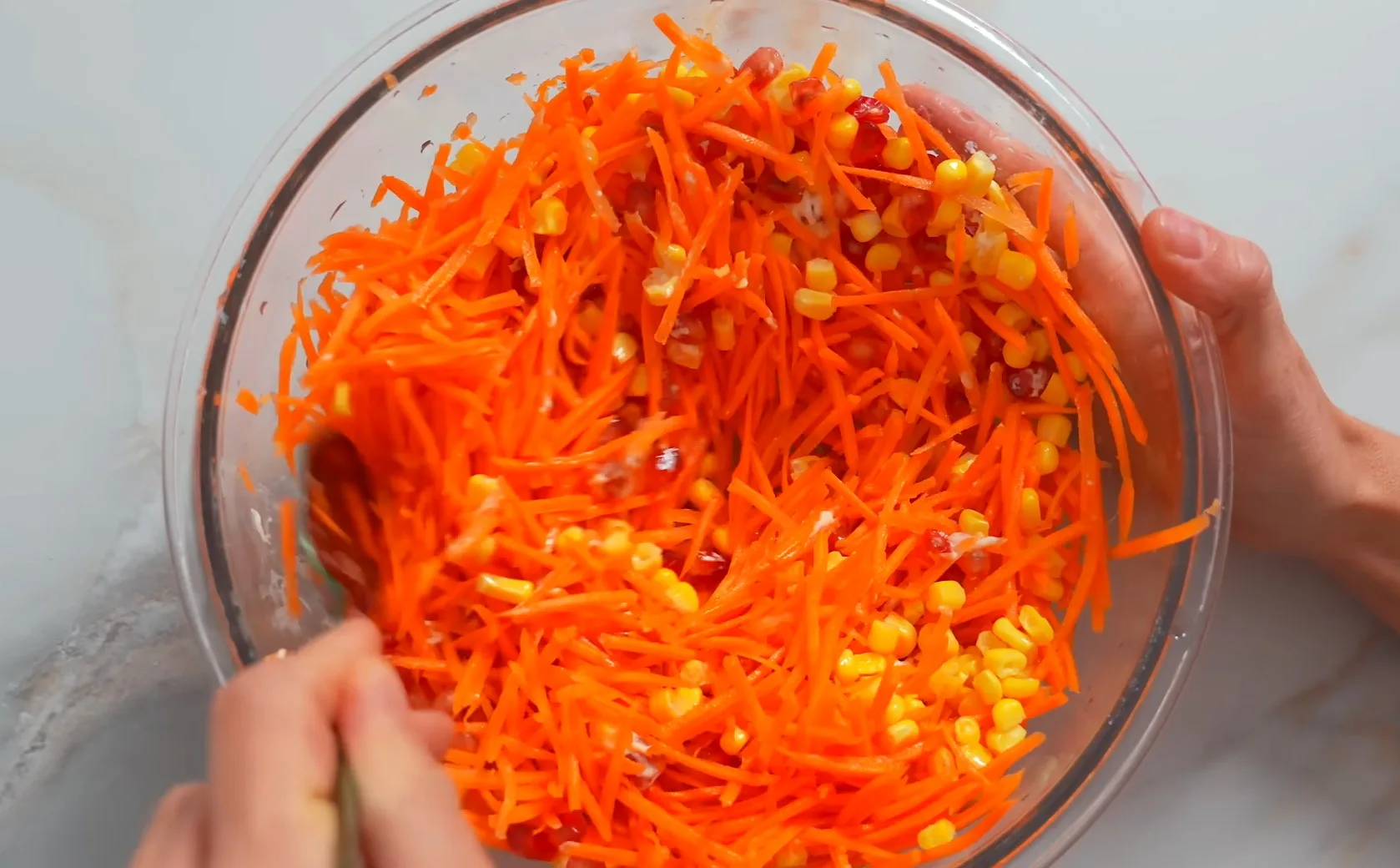 Тертая свежая морковь, зерна граната и кукуруза в глубокой тарелке