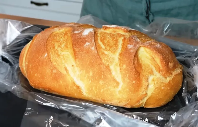 Румяная буханка домашнего хлеба с надрезами и хрустящей корочкой