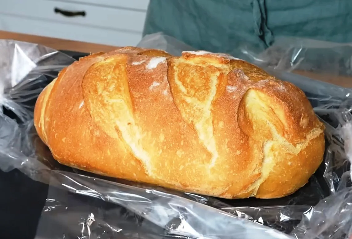 Румяная буханка домашнего хлеба с надрезами и хрустящей корочкой