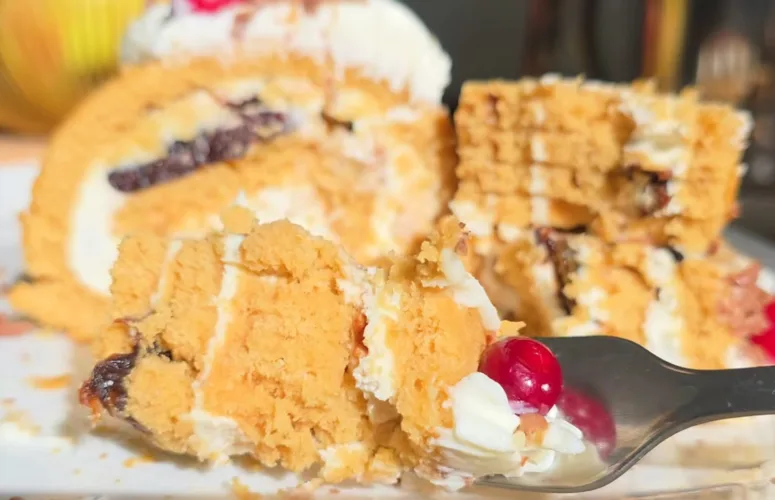 Аппетитный срез медового рулета с белым кремом, кусочками чернослива и грецкими орехами