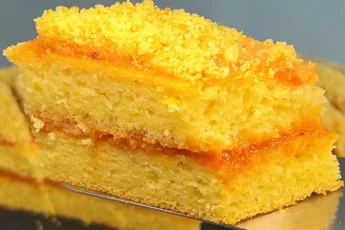 Высокий многослойный пирог на кефире, пропитанный темным повидлом и посыпанный бисквитной крошкой