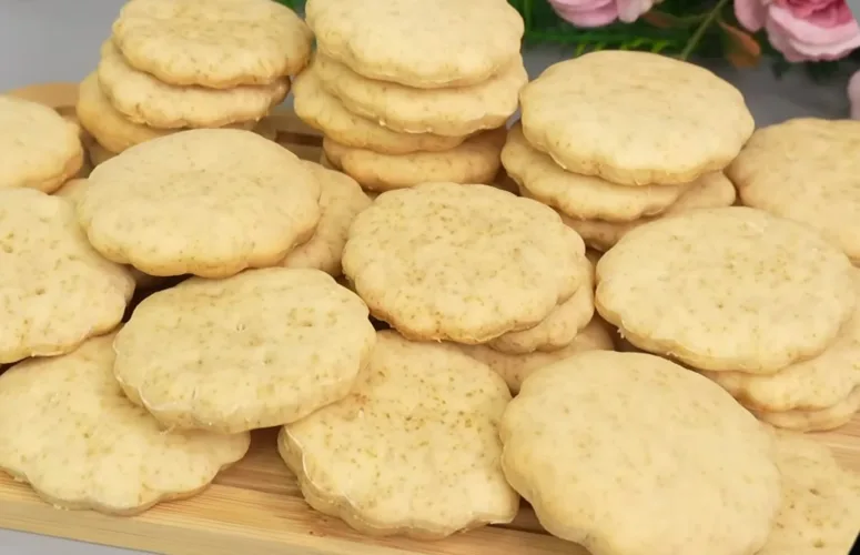Горка круглых золотистых печений «Мария» с характерными дырочками на поверхности, лежащих на тарелке