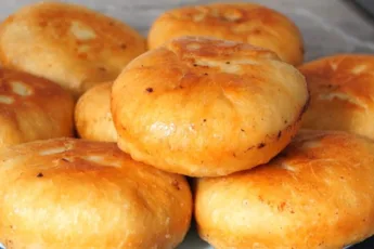 Золотистые жареные беляши на тарелке