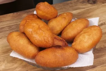 Горка румяных жареных пирожков на тарелке