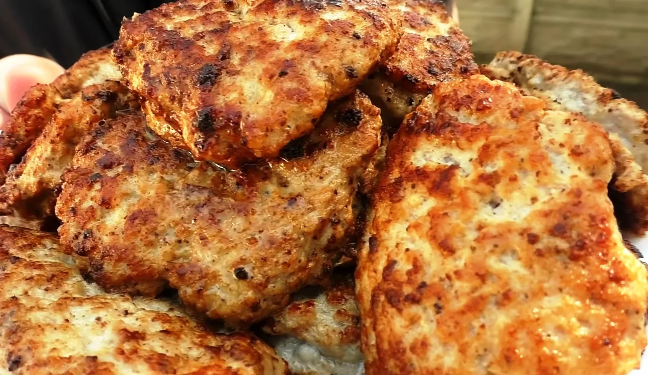 Пышные румяные мясные оладьи, обжаренные на сковороде,