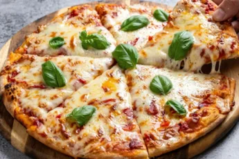 Пышная домашняя пицца с красным томатным соусом и расплавленной моцареллой в круглой форме