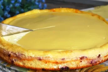 Творожная запеканка с малиной и сметанной заливкой в круглой форме на столе