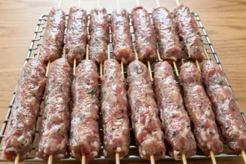 Сырые люля-кебабы на деревянных шпажках