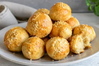 Маленькие круглые пирожки с ямочками посередине, посыпанные кунжутом