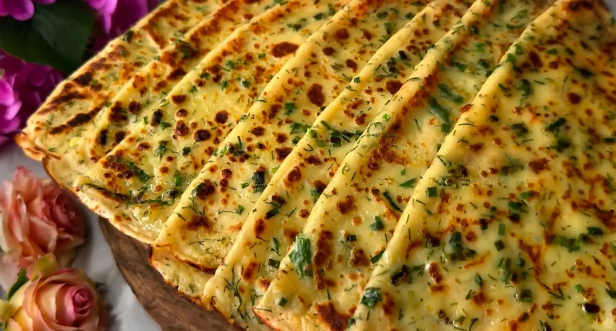 Румяные полукруглые лепешки с зеленью, смазанные маслом