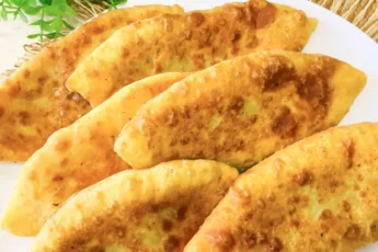 Золотистые продолговатые пирожки с мясом, обжаренные в масле