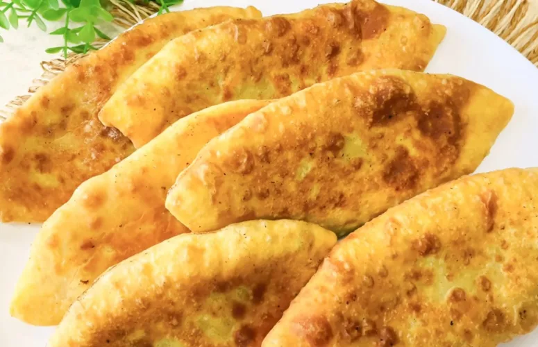 Золотистые продолговатые пирожки с мясом, обжаренные в масле