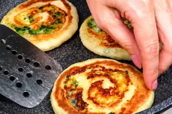 Лепёшки-улитки на кефире с сыром и зеленым луком на сковороде