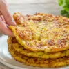 Золотистые кабачковые хачапури с тягучей сырной начинкой на тарелке