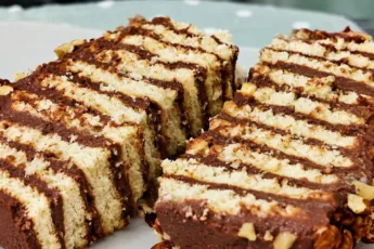 Быстрый домашний шоколадный торт из печенья и заварного какао-крема, посыпанный грецкими орехами