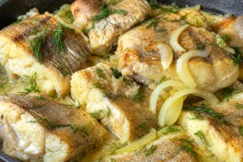 Сочные кусочки жареной рыбы с карамелизированным луком, посыпаны свежим укропом