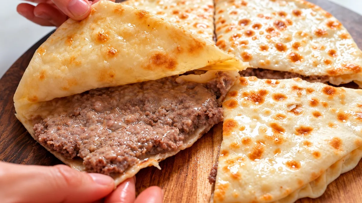 Румяный закрытый мясной пирог с сочной начинкой из фарша и лука, обжаренный на сковороде