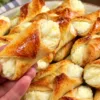 Большая стопка золотистого песочного печенья в виде трубочек с нежной творожной начинкой на прямоугольном подносе