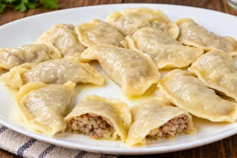 Горячие вареники с капустно-мясной начинкой на тарелке